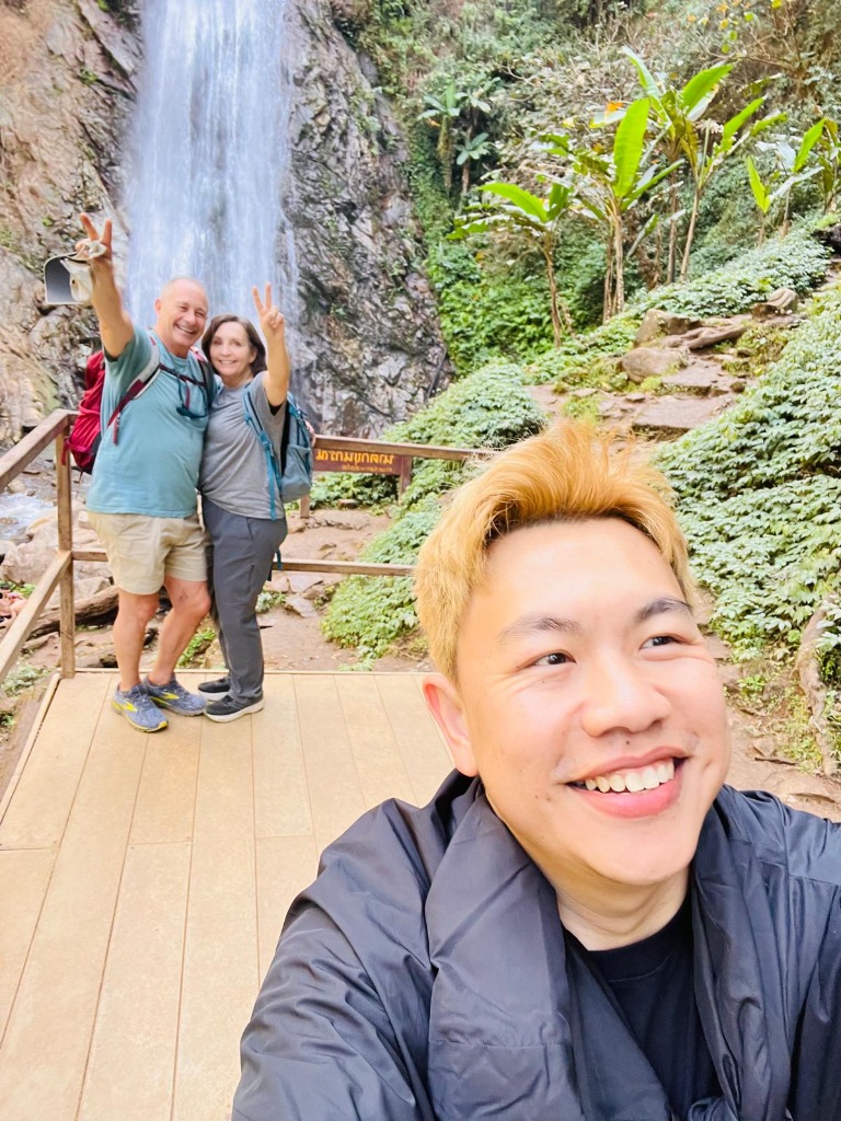 Smiling travelers at Khun Korn Waterfall bridge